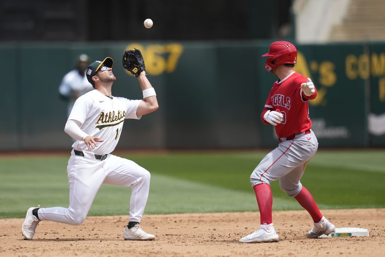 Max Schuemann, izquierda, campocorto de los Atléticos de Oakland, atrapa un elevado de Willie Calhoun, de los Angelinos de Los Ángeles, mientras Taylor Ward, derecha, observa durante la quinta entrada del juego de béisbol del domingo 21 de julio de 2024, en Oakland, California. (AP Foto/Jeff Chiu)