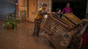 Personas limpian sus viviendas afectadas por las inundaciones en Utiel, España, el miércoles 30 de octubre de 2024. (AP Foto/Manu Fernández)