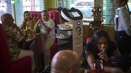 Los clientes observan cómo un robot llega con su comida al restaurante Doña Alicia en La Habana, el miércoles 15 de abril de 2025. (AP Foto/Ramón Espinosa)