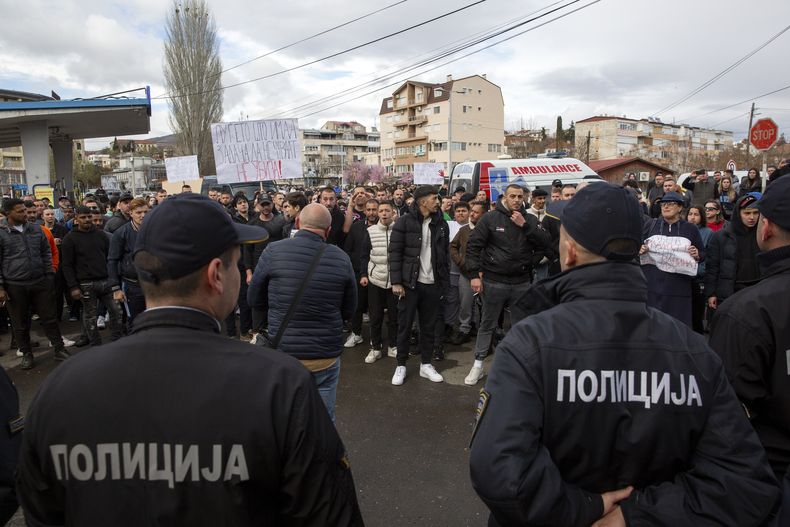 Un grupo de personas se enfrenta a la policía cerca de la casa del propietario de un club nocturno que se incendió, tras una vigilia por las víctimas, en la localidad de Kocani, en Macedonia del Norte, el 17 de marzo de 2025. (AP Foto/Visar Kryeziu)