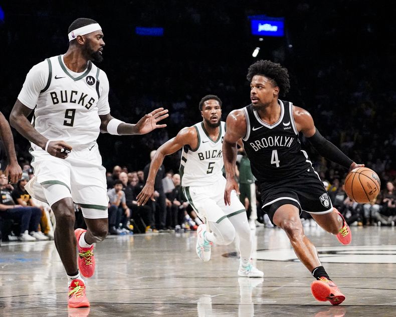 El base de los Nets de Brooklyn Dennis Smith Jr. avanza hacia la canasta frente al alero de los Bucks de Milwaukee Bobby Portis en el encuentro del miércoles 27 de diciembre del 2023. (AP Foto/Peter K. Afriyie)