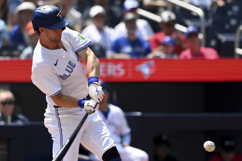 Ernie Clement, de los Azulejos de Toronto, batea un doble contra los Rangers de Texas en la primera entrada en Toronto, el domingo 28 de julio de 2024. (Jon Blacker/The Canadian Press vía AP)