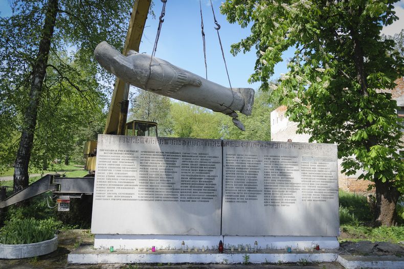 Empleados municipales desmantelan un monumento de la era soviética a los soldados que murieron durante la Segunda Guerra Mundial, en la aldea de Pnikut, en la región de Leópolis, Ucrania, el viernes 12 de mayo de 2023. (AP Foto/Mykola Tys)