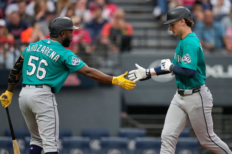 Colt Emerson (derecha), de los Marineros de Seattle, es felicitado por Randy Arozarena (56) tras conectar un jonrón en la tercera entrada de un partido de béisbol contra los Guardianes de Cleveland, en Cleveland, el viernes 26 de junio de 2026. (Foto AP/Sue Ogrocki)