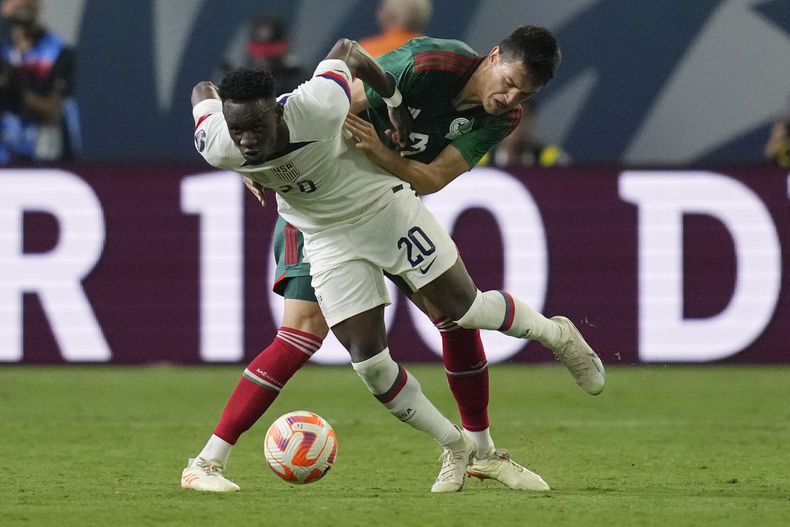 El estadounidense Folarin Balogun y el mexicano César Montes disputan un balón en la primera mitad del partido por las semifinales de la Liga de Naciones de CONCACAF, el jueves 15 de junio de 2023, en Las Vegas. (AP Foto/John Locher)