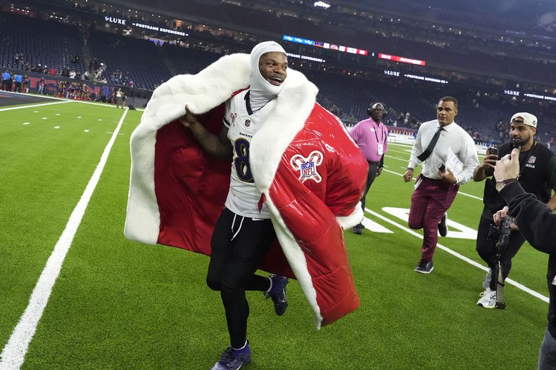Lamar Jackson, quarterback de los Ravens de Baltimore, abandona el campo con un abrigo de Santa Claus, tras la victoria sobre los Texans de Houston, el miércoles 25 de diciembre de 2024 (AP Foto/David J. Phillip)