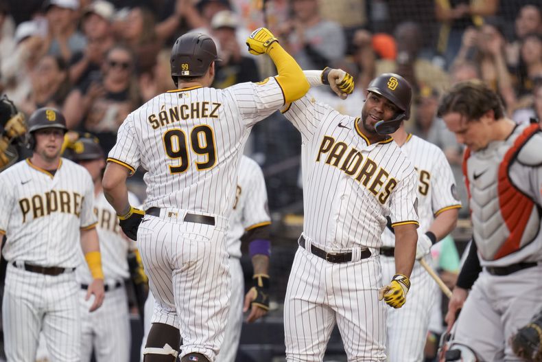 El dominicano Gary Sánchez (99) de los Padres de San Diego es felicitado por su compañero Xander Bogaerts (derecha), tras conectar un grand slam en el primer episodio del juego ante los Orioles de Baltimore, en San Diego. Martes 15 de agosto de 2023. (AP Foto/Gregory Bull)