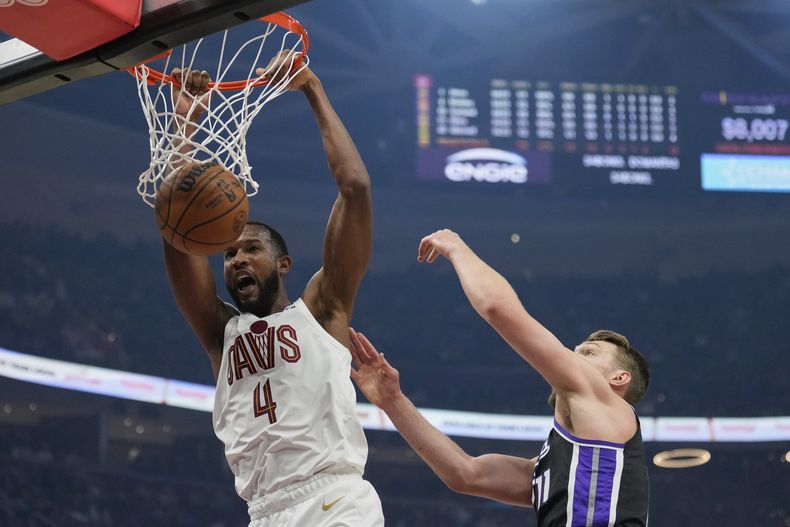 El alero de los Cavaliers de Cleveland, Evan Mobley (4), clava frente al alero de los Kings de Sacramento, Domantas Sabonis, a la derecha, en la primera mitad de un partido de baloncesto de la NBA, el domingo 6 de abril de 2025, en Cleveland. (AP Foto/Sue Ogrocki)