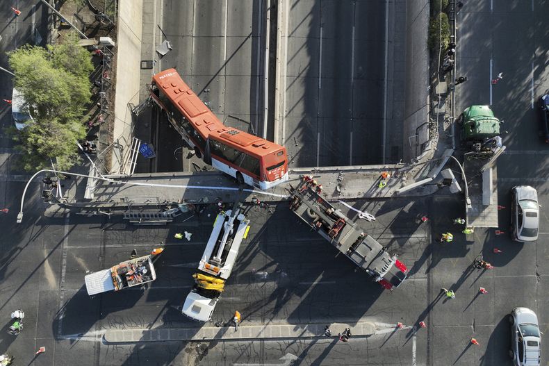 Un autobús cuelga de un paso elevado tras chocar con un vehículo, en Santiago, Chile, el sábado 19 de abril de 2025. (Foto AP/Javier Torres)