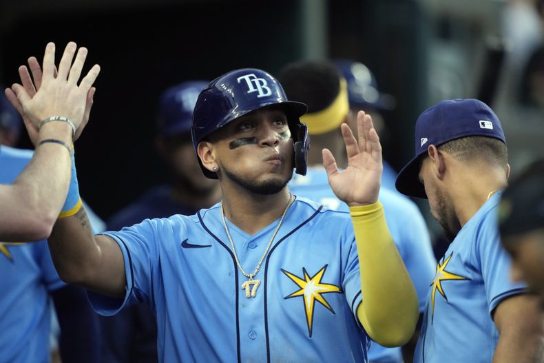 Isaac Paredes, de los Rays de Tampa Bay, es felicitado en la caseta del equipo después de anotar durante la séptima entrada del juego de béisbol en contra de los Tigres de Detroit, el viernes 4 de agosto de 2023, en Detroit. (AP Foto/Carlos Osorio)