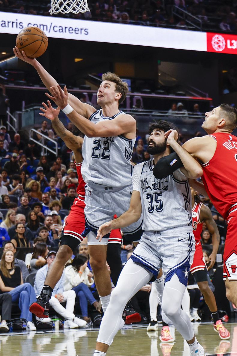 Franz Wagner (22), alero del Magic de Orlando, se estira para atacar el aro entre defensivos de los Bulls de Chicago durante la primera mitad del juego de baloncesto de la NBA, el miércoles 27 de noviembre de 2024, en Orlando, Florida. (AP Foto/Kevin Kolczynski)