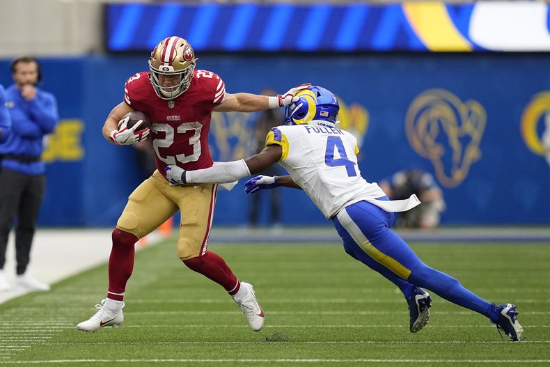 El corredor de los 49ers de San Francisco Christian McCaffrey repele al safety de los Rams de Los Ángeles Jordan Fuller en el encuentro del domingo 17 de septiembre del 2023. (AP Foto/Gregory Bull)
