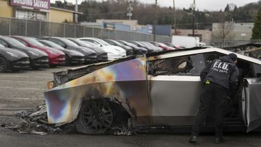 ARCHIVO - Un miembro del departamento de bomberos de Seattle inspecciona un Tesla Cybertruck en un estacionamiento de Tesla en Seattle, el lunes 10 de marzo de 2025. (AP Foto/Lindsey Wasson, Archivo)