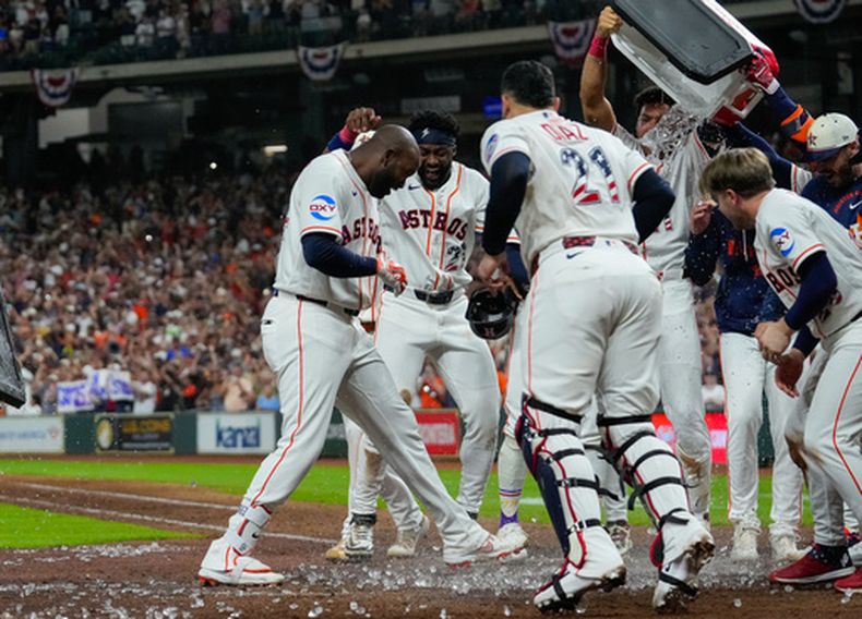 Yordan Alvarez, izquierda, bateador designado de los Astros de Houston, celebra con sus compañeros de equipo después de batear un jonrón de dos carreras decisivo en la novena entrada para dejar tendidos en el terreno a los Rays de Tampa Bay, el sábado 4 de julio de 2026, en Houston. (AP Foto/Jon Shapley)
