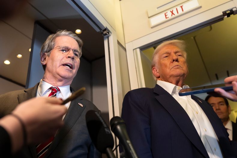 El secretario del Tesoro, Scott Bessent (izquierda), habla con los periodistas mientras el presidente Donald Trump (derecha) escucha a bordo del Air Force One, el lunes 27 de octubre de 2025, durante el viaje de Kuala Lumpur a Tokio. (AP Foto/Mark Schiefelbein)