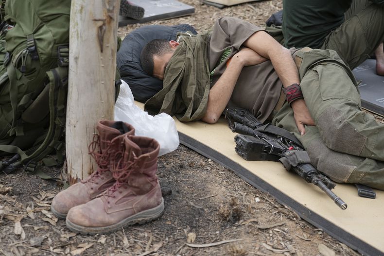 Un soldado israelí descansa cerca de la frontera entre Israel y la Franja de Gaza, el sábado 25 de noviembre de 2023. (AP Foto/Tsafrir Abayov)