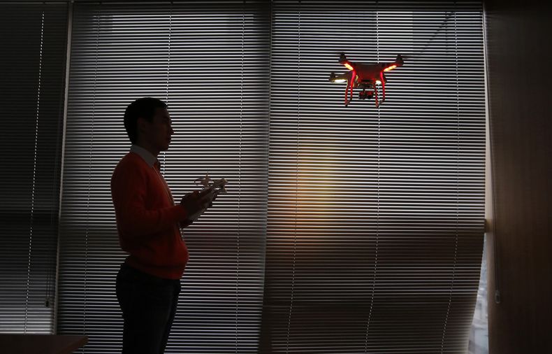 ARCHIVO - Un miembro del personal de la compañía DJI Technology Co. vuela un dron dentro de su oficina en Shenzhen, China, el 15 de diciembre de 2014. (AP Foto/Kin Cheung, Archivo)