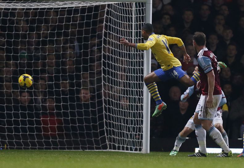 El jugador de Arsenal, Theo Walcott, segundo desde la derecha, anota un gol contra West Ham en la liga Premier el jueves, 26 de diciembre de 2013, en Londres. (AP Photo/Sang Tan)