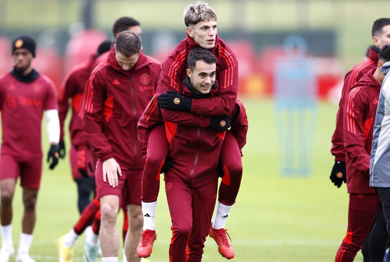 Sergio Reguilón (centro) carga a su compañero Alejandro Garnacho durante un entrenamiento del Manchester United, el lunes 11 de diciembre de 2023 en Manchester. (Richard Sellers/PA vía AP)