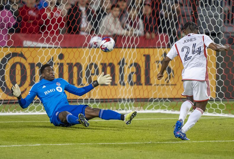 DeJuan Jones, del Revolution de Nueva Inglaterra, marca un gol ante Sean Johnson, arquero de Toronto, el sábado 6 de mayo de 2023, en un partido de la MLS (Frank Gunn/The Canadian Press via AP)