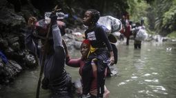 ARCHIVO - Migrantes haitianos atraviesan partes de agua al pasar por el Tapón del Darién desde Colombia a Panamá en su larga y compleja ruta para llegar hasta Estados Unidos, el 9 de mayo de 2023. Colombia y Panamá están fallando en dar protección a los miles de migrantes que cruzan la peligrosa jungla del Darién, como paso previo para avanzar hasta Estados Unidos, y que están más expuestos a los asaltos y la violencia sexual, de acuerdo con un informe de la organización Human Rights Watch publicado el 3 de abril de 2024. (AP Foto/Iván Valencia, Archivo)