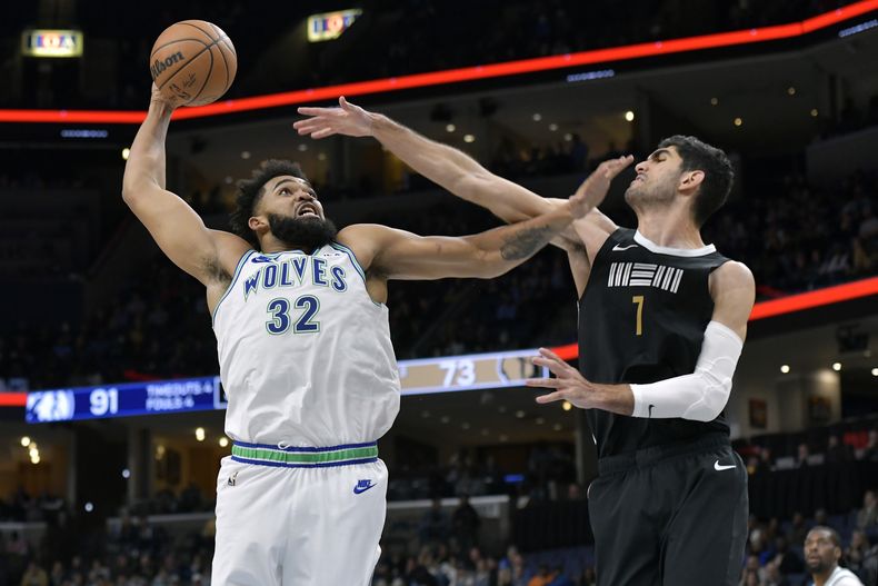 Karl-Anthony Towns (32), de los Timberwolves de Minnesota, ataca el aro ante el intento de bloqueo de Santi Aldama (7), de los Grizzlies de Memphis, durante la segunda mitad del juego de baloncesto de la NBA, el viernes 8 de diciembre de 2023, en Memphis, Tennessee. (AP Foto/Brandon Dill)