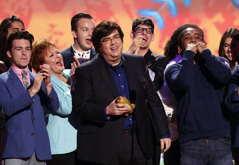 ARCHIVO - Dan Schneider, centro, acepta recibe un premio en Los Ángeles el 29 de marzo de 2014. Schneider demandó a los creadores de Quiet on Set: The Dark Side of Kids TV el miércoles 1 de mayo de 2024, alegando que los creadores del documental implicaron indebidamente que abusó sexualmente de actores menores de edad con los que trabajó. (Foto Matt Sayles/Invision/AP, archivo)