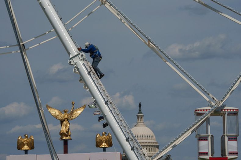 El Capitolio de EEUU se ve al fondo de una noria durante los preparativos de la Gran Feria de Estados de Estados Unidos en el National Mall, el domingo 21 de junio de 2026 en Washington. (AP Foto/Jon Elswick