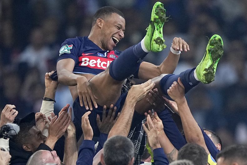 Kylian Mbappé, del París Saint-Germain, es lanzado por los aires durante la celebración por la conquista de la Copa de Francia, el sábado 25 de mayo de 2024, tras vencer en la final a Lyon (AP Foto/Michel Euler)