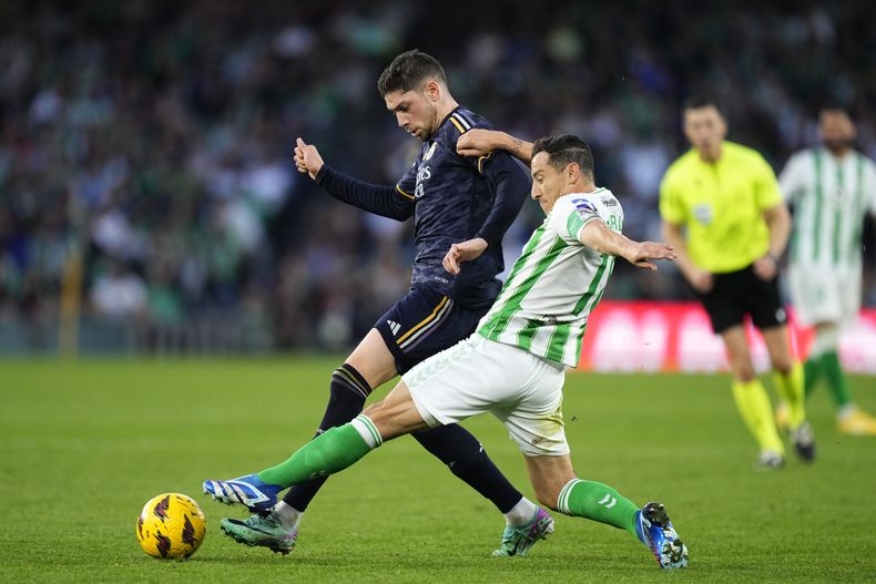 ARCHIVO - Federico Valverde (izquierda) del Real Madrid y Andrés Guardado del Real Betis pugnan por el balón en un partido de la Liga de España, el 9 de diciembre de 2023, en Sevilla. (AP Foto/José Bretón)