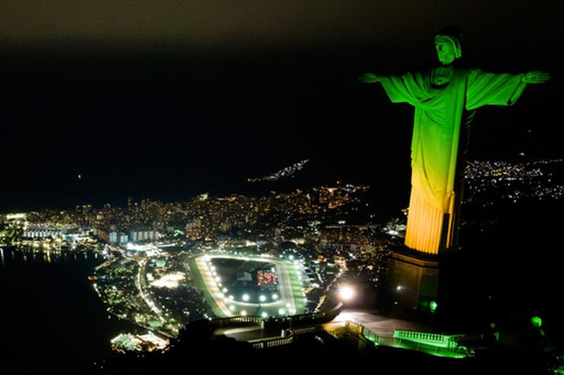 La estatua del Cristo Redentor iluminada con los colores nacionales de Brasil como parte de la cuenta regresiva hacia el Mundial Femenino 2027, el martes 23 de junio de 2026, en Río de Janeiro. (AP Foto/Dhavid Normando)