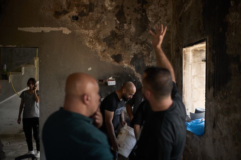 Varios palestinos se reúnen para reparar una vivienda dañada tras un ataque perpetrado el día anterior por colonos israelíes en el poblado de Sarra, cerca de la ciudad de Naplusa, Cisjordania, el sábado 25 de julio de 2026. (AP Foto/Leo Correa)