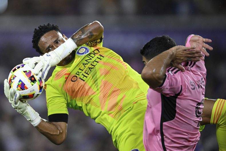 El peruano Padro Gallese, arquero de Orlando City, choca con el uruguayo Luis Suárez, delantero del Inter Miami, durante un partido disputado el miércoles 15 de mayo de 2024 (AP Foto/Phelan M. Ebenhack)