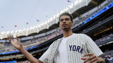 El basquetbolista francés Victor Wembanyama se dispone a hacer el primer lanzamiento del juego del martes 20 de junio de 2023, entre los Yanquis de Nueva York y los Marineros de Seattle (AP Foto/John Minchillo)