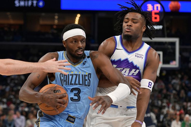 Jerami Grant, alero de los Grizzlies de Memphis, elude a Isaiah Collier, del Jazz de Utah, en el encuentro del miércoles 21 de octubre de 2026 (AP Foto/Brandon Dill)
