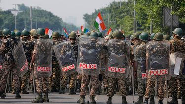 Personal de seguridad con equipo antimotines llega para escoltar a trabajadores del partido opositor Congreso, que se reúnen en una marcha hacia la Corte Suprema para exigir la renuncia del jefe electoral del país, Gyanesh Kumar, en Nueva Delhi, India, el lunes 12 de octubre de 2026. (AP Foto/Manish Swarup)