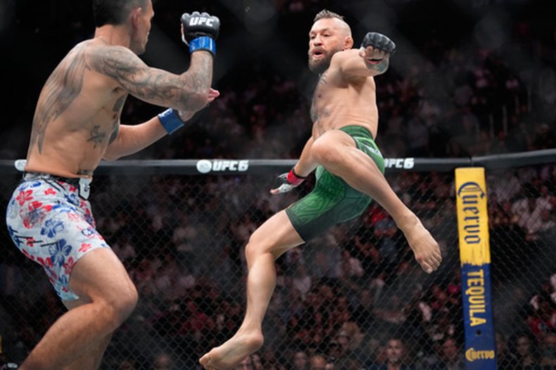 Conor McGregor, a la derecha, salta para dar una patada mientras pelea contra Max Holloway en un combate de peso wélter en el evento de artes marciales mixtas UFC 329 el sábado 11 de julio de 2026 en Las Vegas. (Foto AP/John Locher)