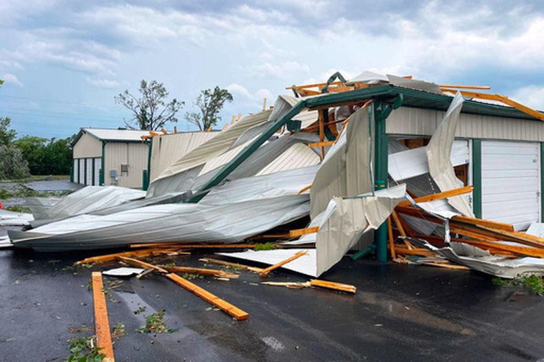 En esta fotografía proporcionada por Christian Jensen, trozos de metal retorcido y tablones de madera de un edificio dañado por una fuerte tormenta cubren el pavimento, el lunes 27 de julio de 2026, en Menasha, Wisconsin. (Christian Jensen vía AP)