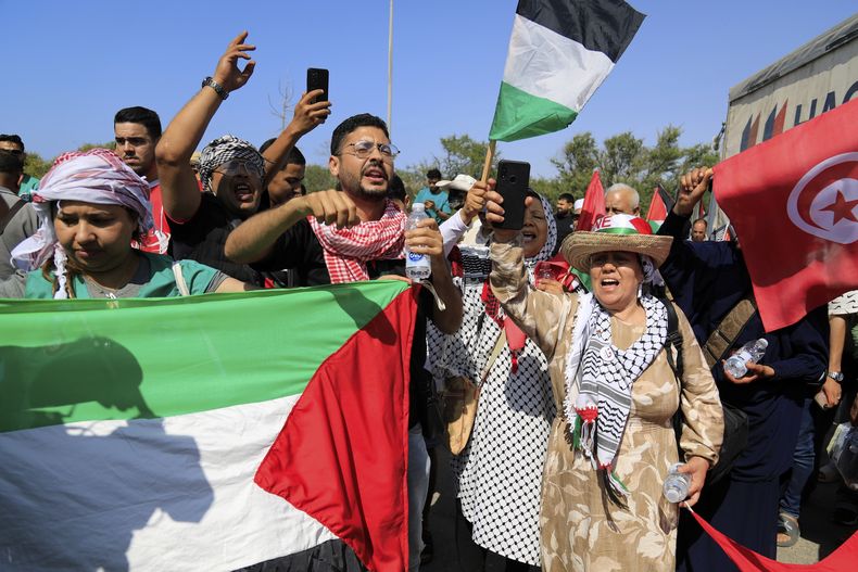 Miembros de un convoy humanitario de al menos 1.500 personas, entre ellas activistas y simpatizantes de Argelia y Túnez, gritan consignas propalestinas mientras se reúnen en su camino a Gaza a través del cruce de Rafah, en Egipto, en Zawiya, Libia, el martes 10 de junio de 2025. (AP Foto/Yousef Murad)