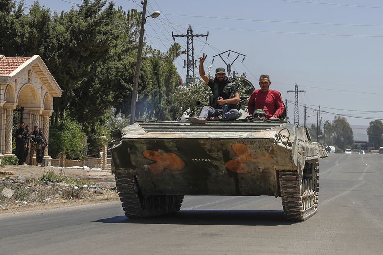 Miembros de las fuerzas gubernamentales sirias, en un vehículo armado durante su retirada de la ciudad de Sweida, en el sur de Siria, el 15 de julio de 2025.(AP Foto/Ghaith Alsayed)