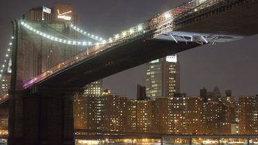 Láminas cuelgan del Puente de Brooklyn después de que una grúa que era transportada en un barco chocó contra la parte inferior del puente, el lunes 13 de marzo de 2012, en Nueva York. (AP Foto/John Minchillo, Archivo)