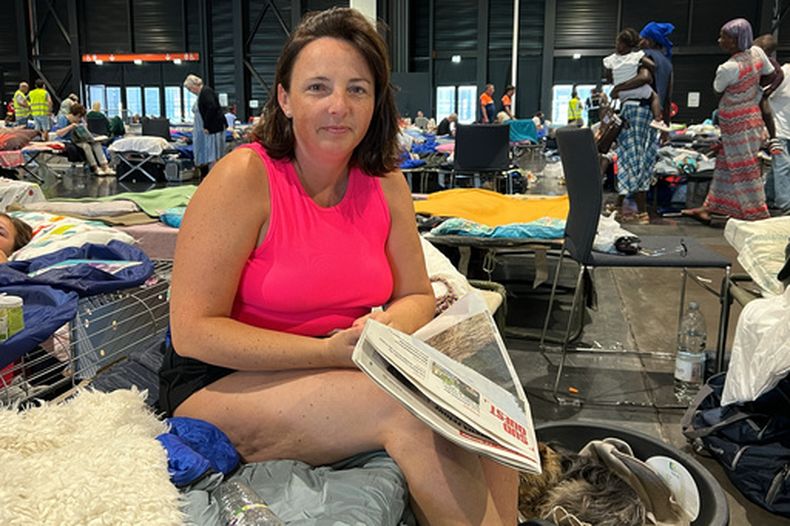 Morgane Bonichot, de 40 años, se toma un descanso de leer el periódico en un centro de evacuación en Burdeos, el 28 de julio de 2026, donde ella, su hija, su conejo y su perro se refugian de los incendios en el sur de Francia. (AP Foto/Eva van Dam)