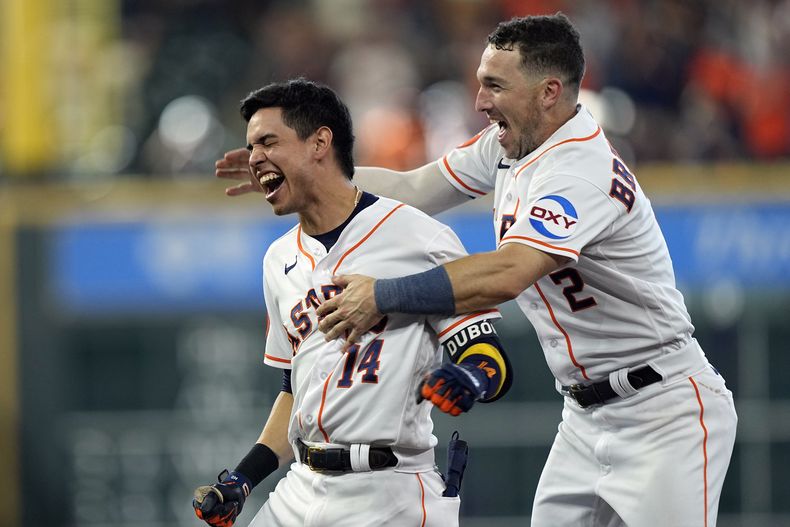 Mauricio Dubón (14), de los Astros de Houston, celebra con Alex Bregman (2) después de batear el sencillo productor de la carrera de la victoria en la novena entrada en contra de los Orioles de Baltimore, el miércoles 20 de septiembre de 2023, en Houston. Los Astros vencieron 2-1 a los Orioles. (AP Foto/David J. Phillip)