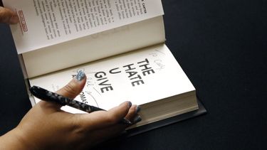 Angie Thomas, de 30 años, residente de Jackson, Mississippi, cuyo libro, The Hate U Give, ha estado en la lista nacional de los libros más vendidos para adultos jóvenes durante 82 semanas, termina de autografiar una copia de su libro en una recepción en Jackson, Mississippi el 10 de octubre de 2018. (Foto AP/Rogelio V. Solis)