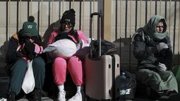 Migrantes con cita previa esperan para presentar sus documentos a agentes de inmigración estadounidenses como parte de sus solicitudes de asilo, en el puente internacional Paso del Norte en Ciudad Juárez, México, en la frontera con El Paso, Texas, el lunes 20 de enero de 2025, día de la toma de posesión del presidente estadounidense Donald Trump. (AP Foto/Christian Chavez)