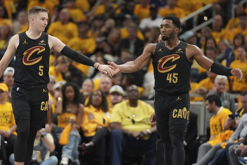 Sam Merrill (5) y Donovan Mitchell (45), de los Cavaliers de Cleveland, festejan en el tercer partido de la semifinal de la Conferencia Este ante los Pacers de Indiana, el viernes 9 de mayo de 2025 (AP Foto/Michael Conroy)
