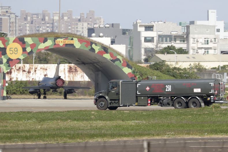 Un vehículo militar taiwanés pasa junto a un avión en una base aérea en Hsinchu, en el norte de Taiwán, el 11 de diciembre de 2024. (AP Foto/Chiang Ying-ying)