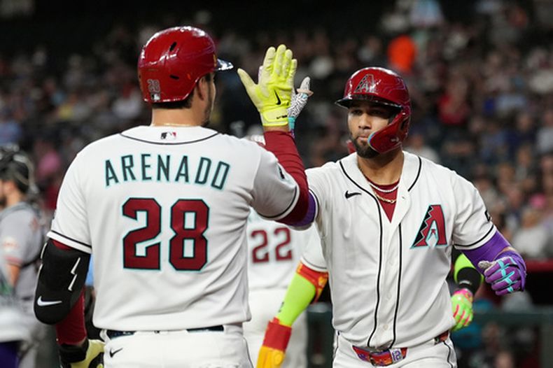 Lourdes Gurriel Jr. (derecha), de los Diamondbacks de Arizona, celebra su jonrón de tres carreras contra los Gigantes de San Francisco junto a su compañero de equipo Nolan Arenado (28) durante la primera entrada de un partido de béisbol, el martes 30 de junio de 2026, en Phoenix. (Foto AP/Ross D. Franklin)