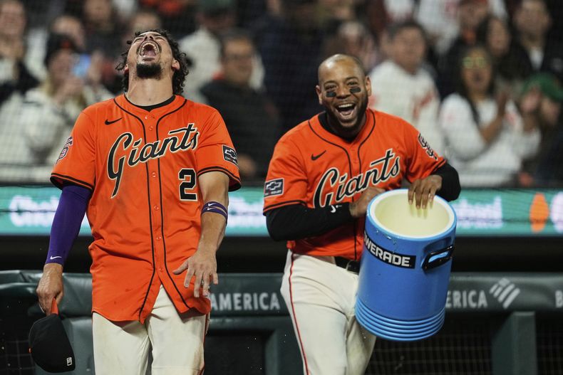 Willy Adames, de los Gigantes de San Francisco, ríe luego de ser empapado con la hielera por Dominic Smith, en el duelo que su equipo ganó ante los Orioles de Baltimore el viernes 29 de agosto de 2025 (AP Foto/Godofredo A. Vásquez)