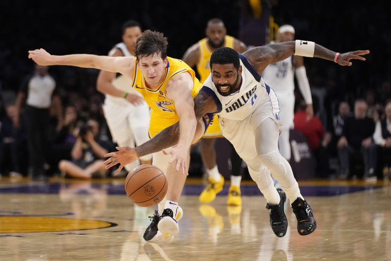 Kyrie Irving (derecha), base de los Mavericks de Dallas, persigue un balón junto a Austin Reaves, de los Lakers de Los Ángeles, el miércoles 22 de noviembre de 2023 (AP Foto/Marcio José Sánchez)
